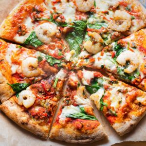 garlic prawn pizza sliced into8 servings on a board