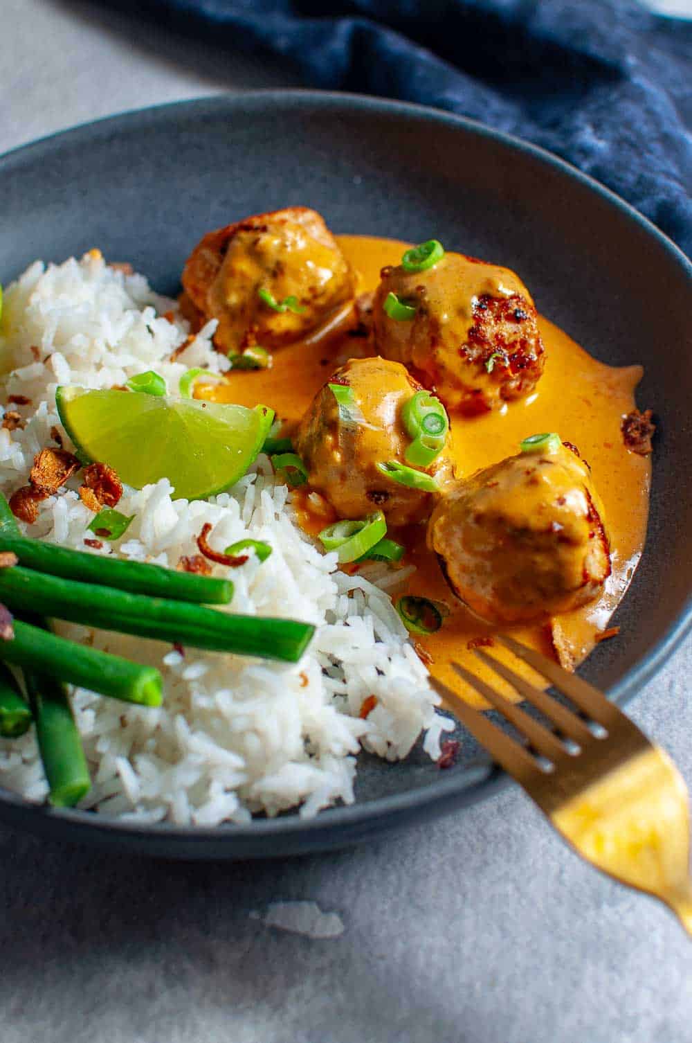 Thai Chicken Meatballs With Peanut Sauce in a bowl with rice