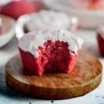 a single red velvet cake with a bite taken out