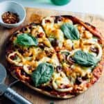 seafood pizza sliced into 8 pieces on a board
