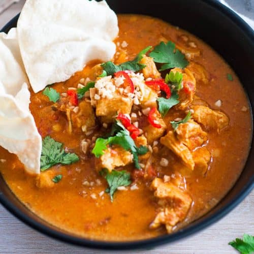 close up of pressure cooker chicken curry in a black bowl