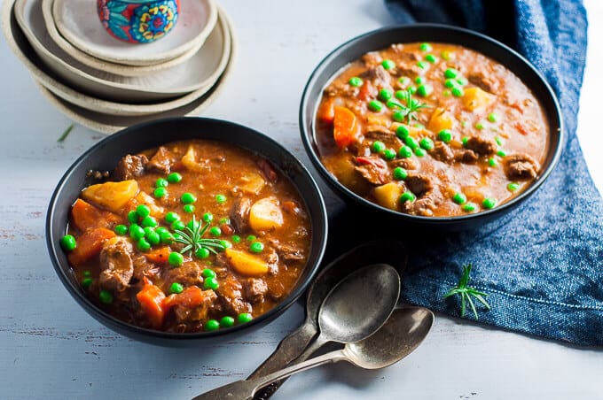 two bowls of pressure cooker lamb stew with spoons