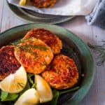 salmon fritters on a plate with lemon