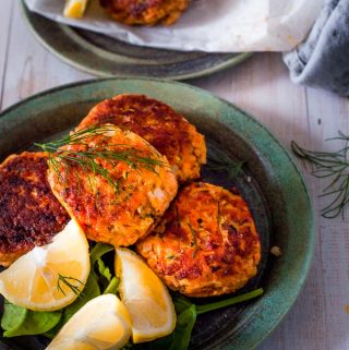 salmon fritters on a plate with lemon