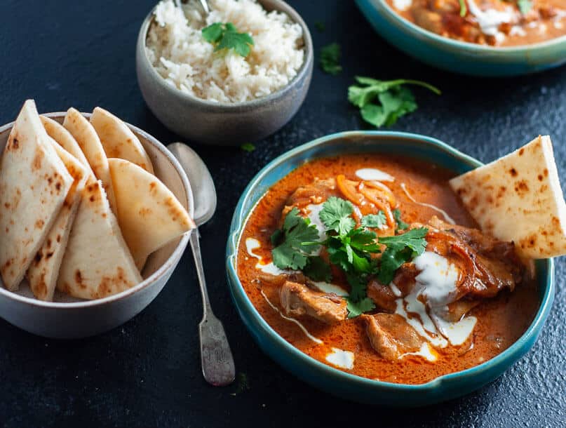 A bow of pressure cooker butter chicken with nan bread