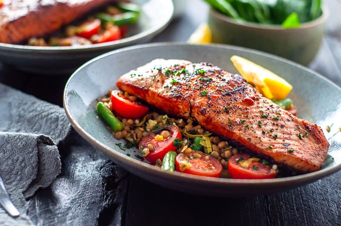 Pan fried salmon in a bowl with tomatoes and beans