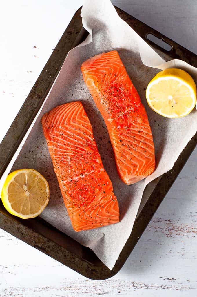 A tray with two fillets of salmon with lemon