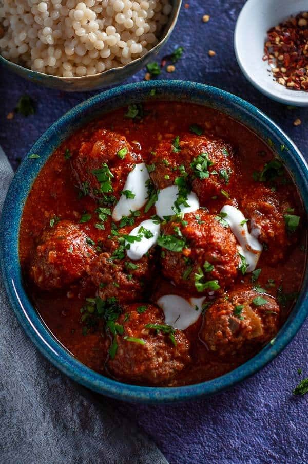 A blue bowl of Slow Cooker Moroccan Meatballs in tomato sauce