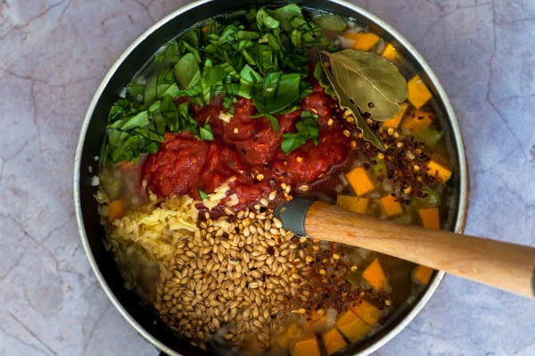 Vegetable and barley soup ingredients in a saucepan