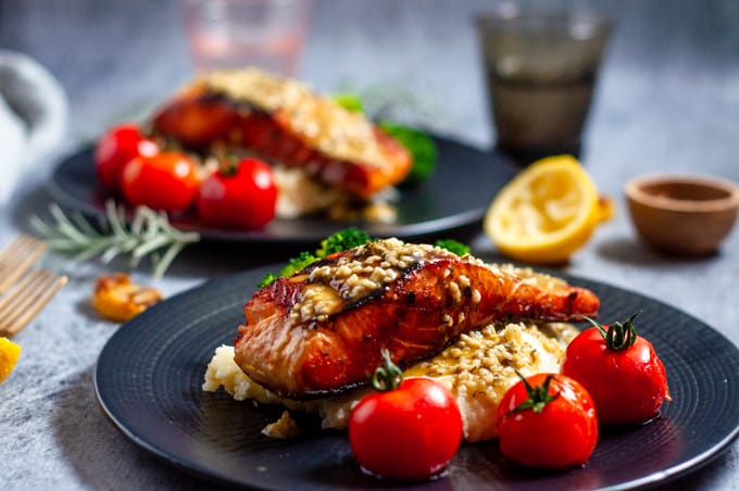 Lemon garlic butter salmon on top of mashed potato with cherry tomatoes