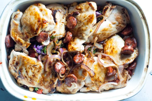 casserole dish with chicken thigh before baking