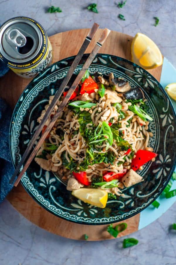 chicken and kale stirfry in a bowl with lemon ready to serve