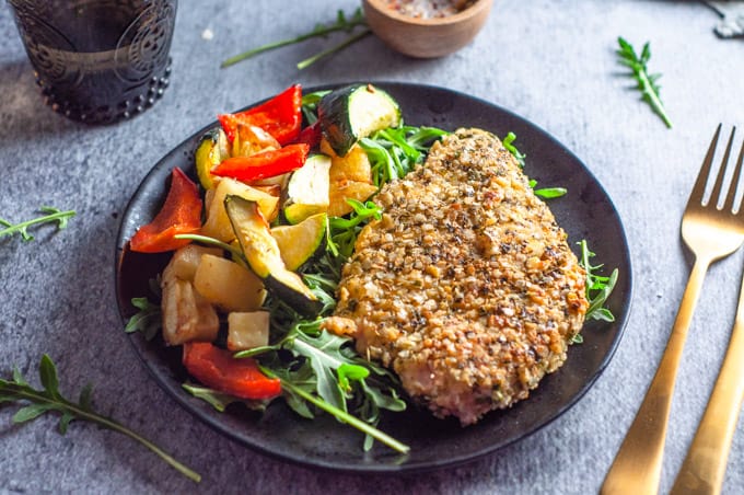 Quinoa crusted chicken on a plate with vgetables