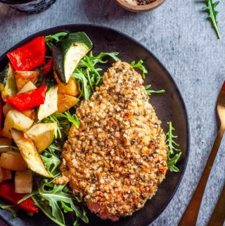 Quinoa Crusted Chicken in a black plate with roast vegetables