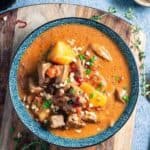 Beef rendag curry in a blue bowl on a cutting board