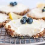 one lemon cream cheese cheesecake on a wire rack with a bite taken out
