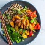 salmon stirfry with rice in a bowl with chopsticks