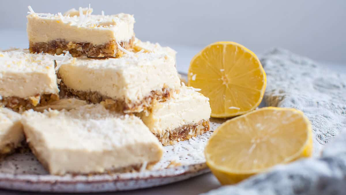 lemon coconut slice stacked on white plate