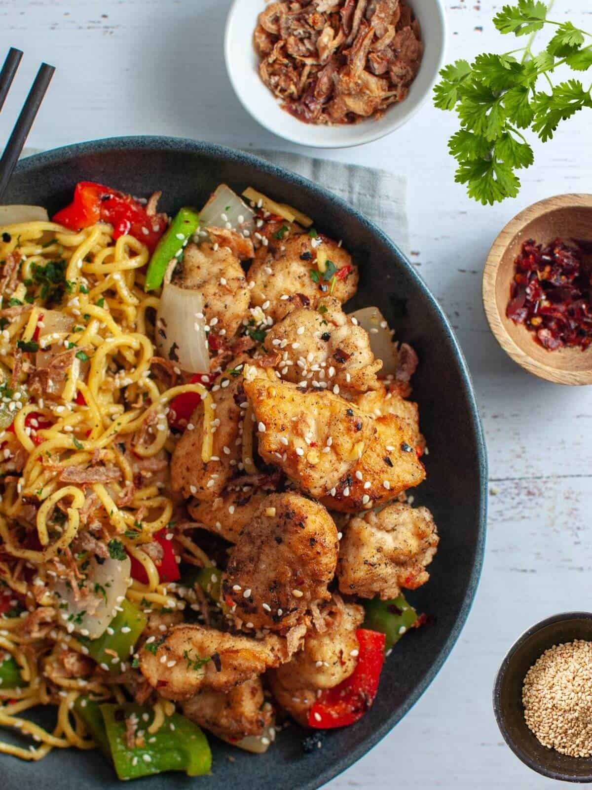 salt and chilli chicken with noodles in a bowl