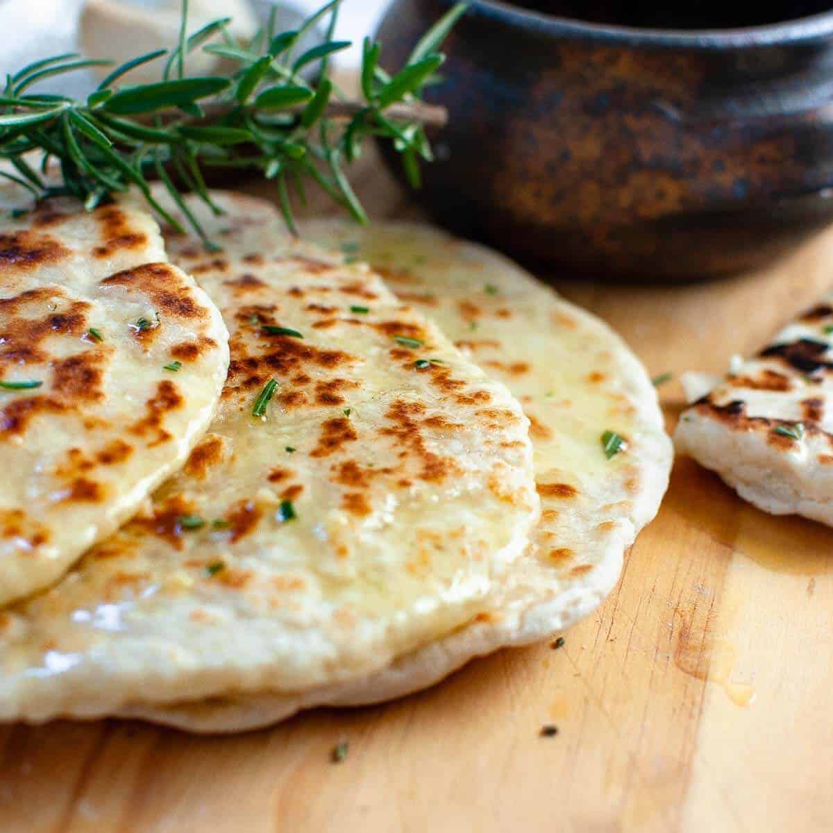 3 flatbreads on a board with rosemary