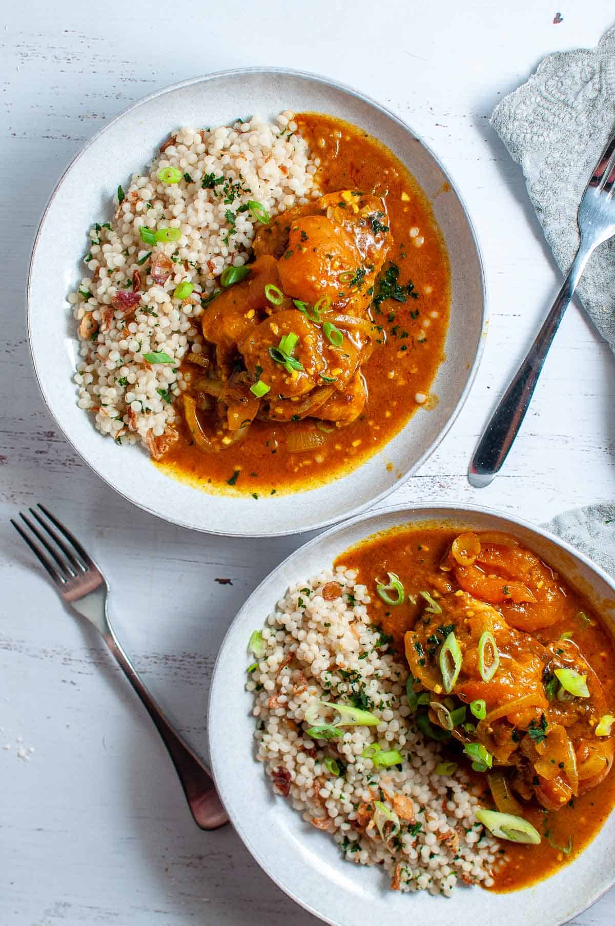 two bowls of apricot chicken curry with cous cous