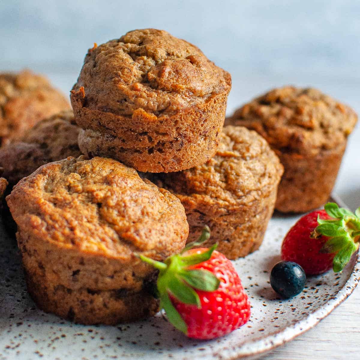 a stack of 5 banana carrot muffins on a plate