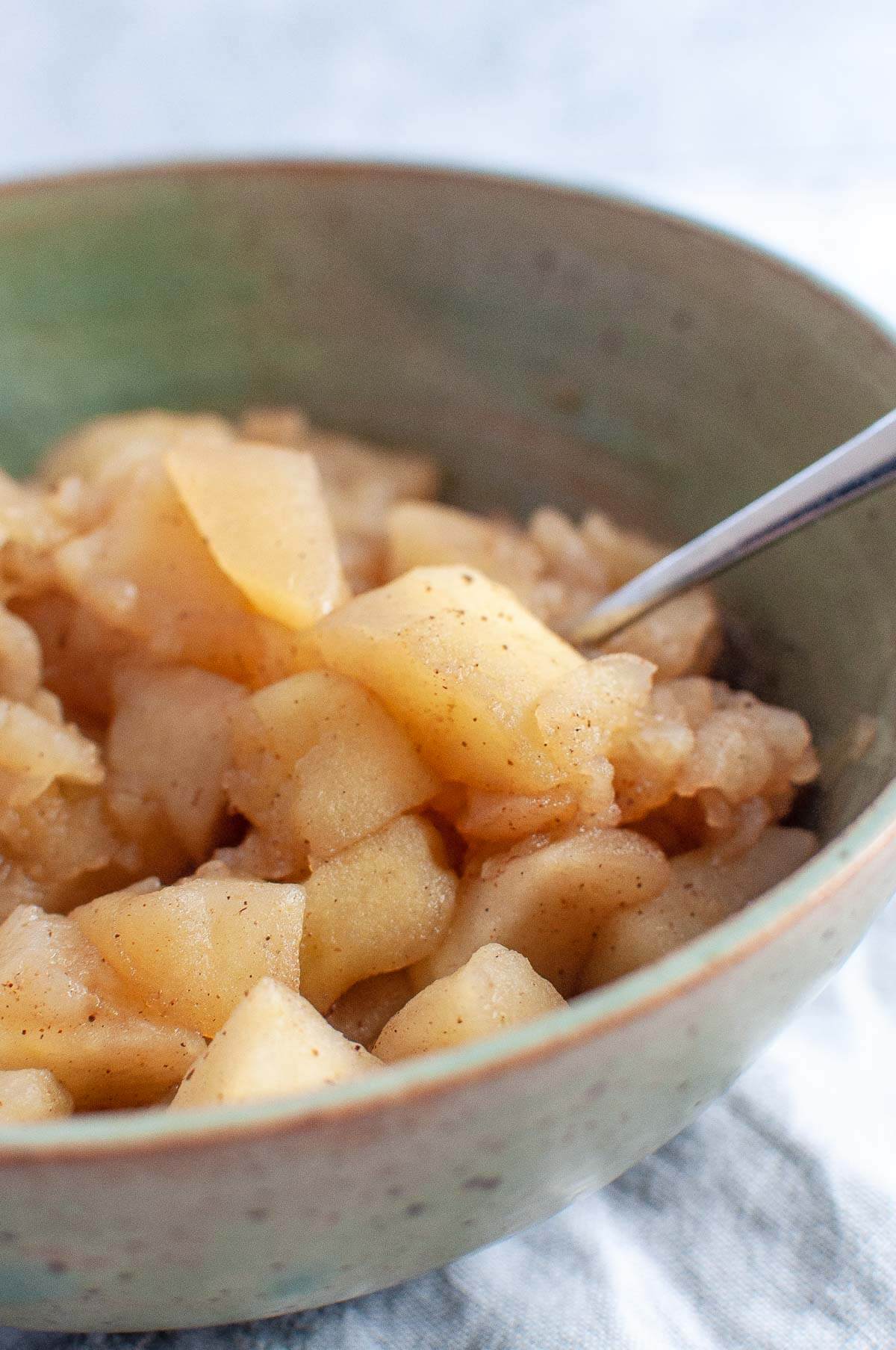 stewed apples in a bowl with a spoon