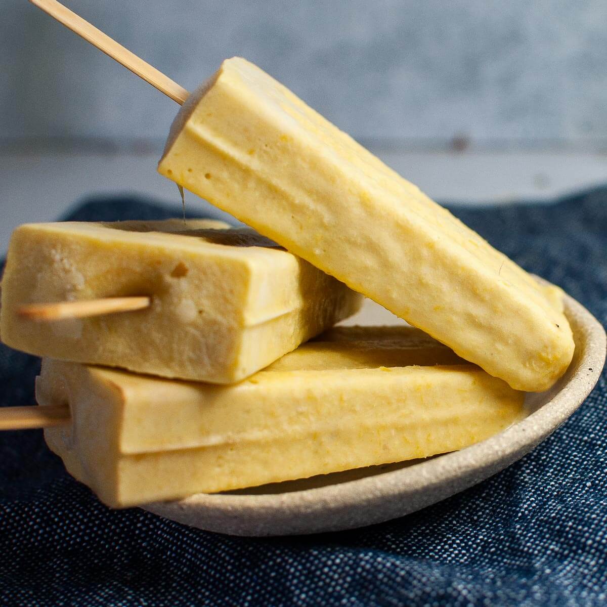 3 mango popsicles on a plate