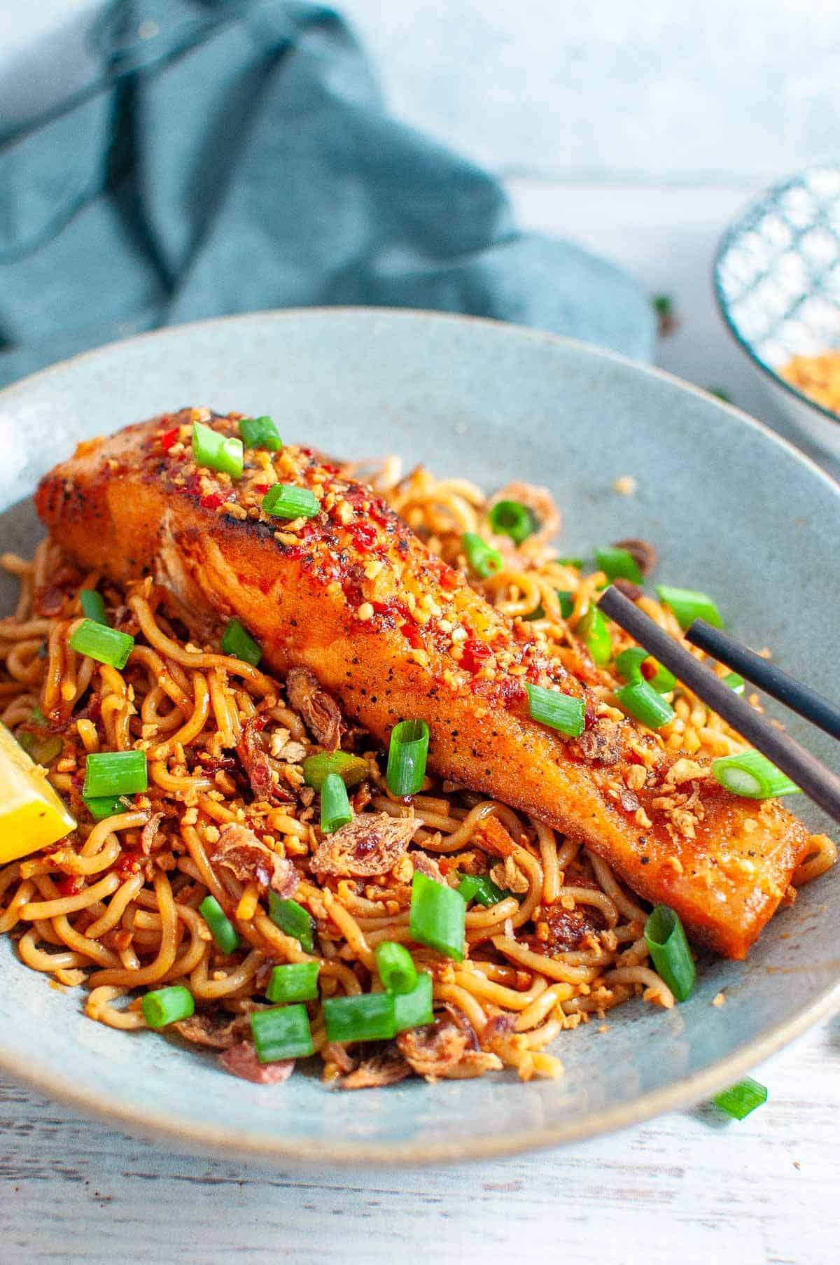 salmon with noodles in a bowl with chopsticks