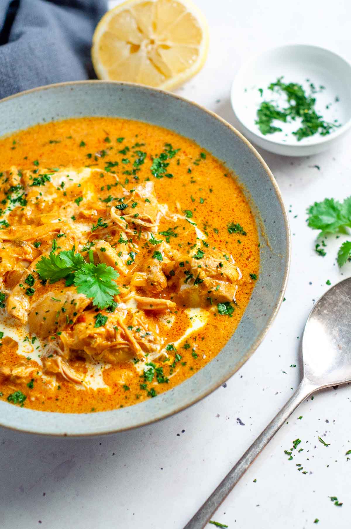 a bowl  of slow cooked chicken masala with lemon and parsley