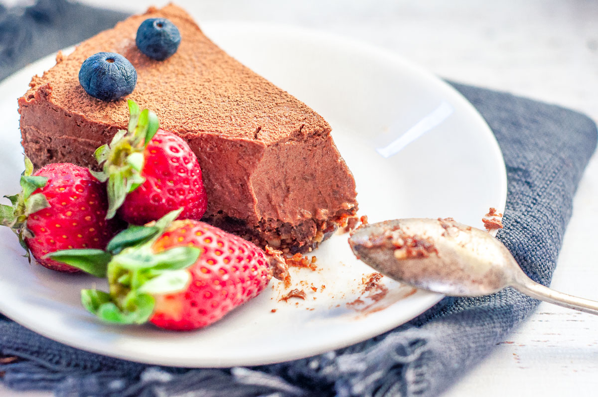 a single slice of cheesecake on a plate with berries