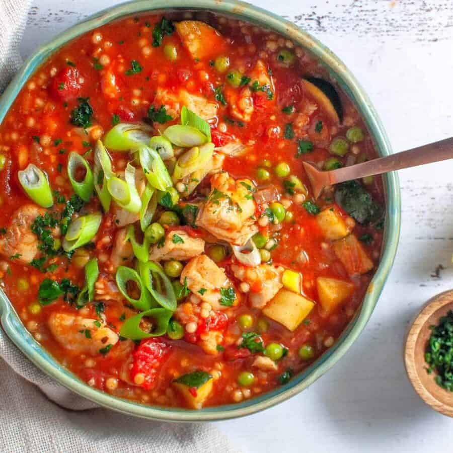 a bowl of spanish fish stew with a fork in