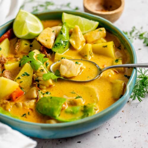 Yellow fish curry in a bowl with spoon