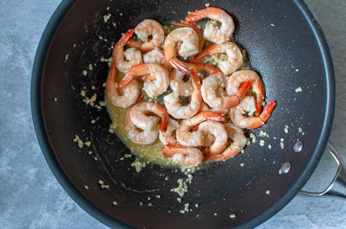 frying off prawns, onion and garlic in a pan