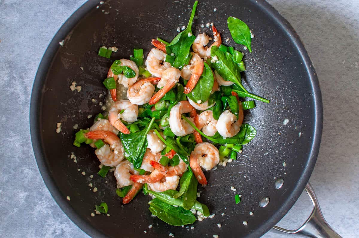 garlic prawns with shallots and spinach in a pan