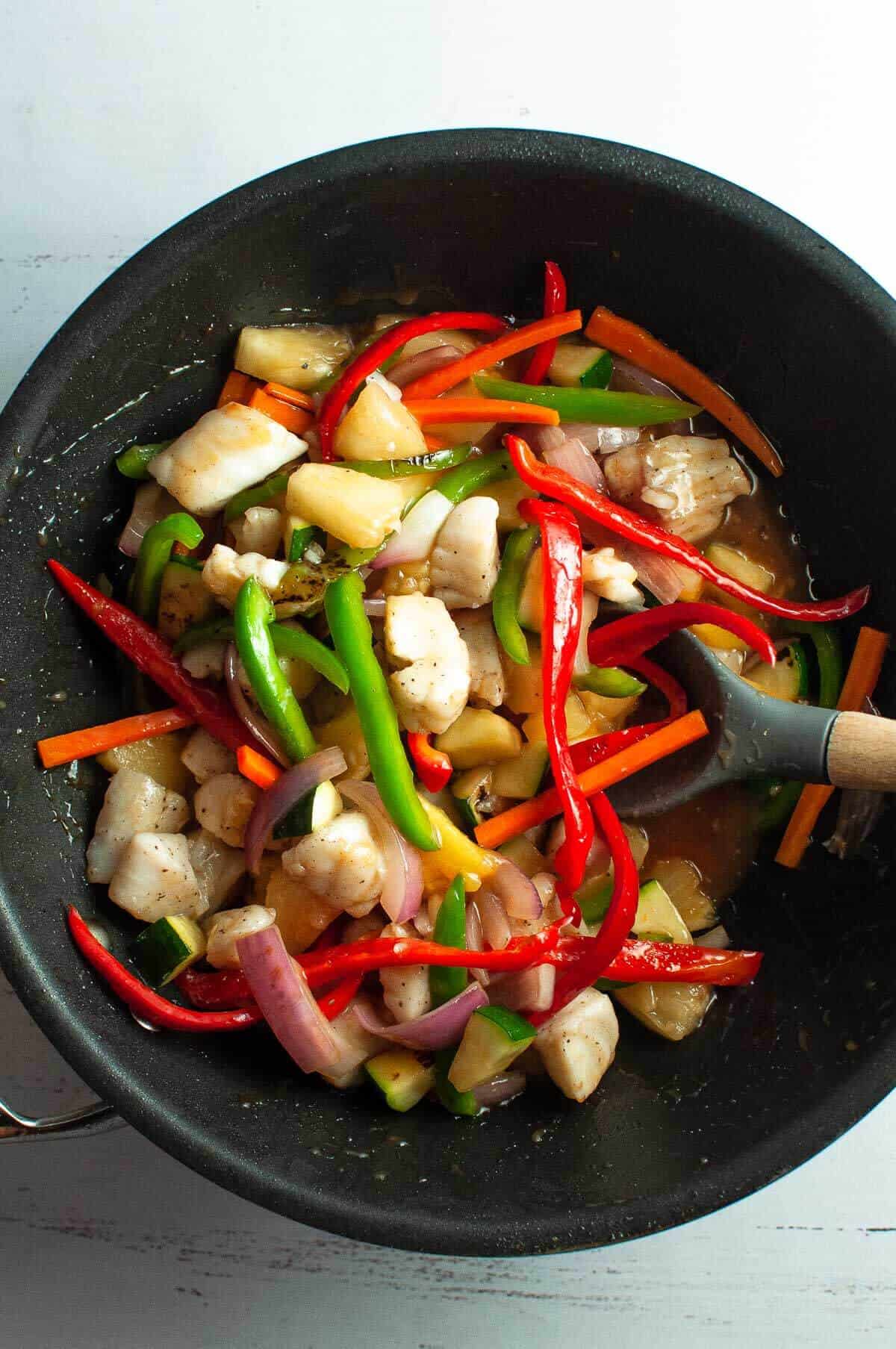 sweet and sour fish in the wok with vegetables