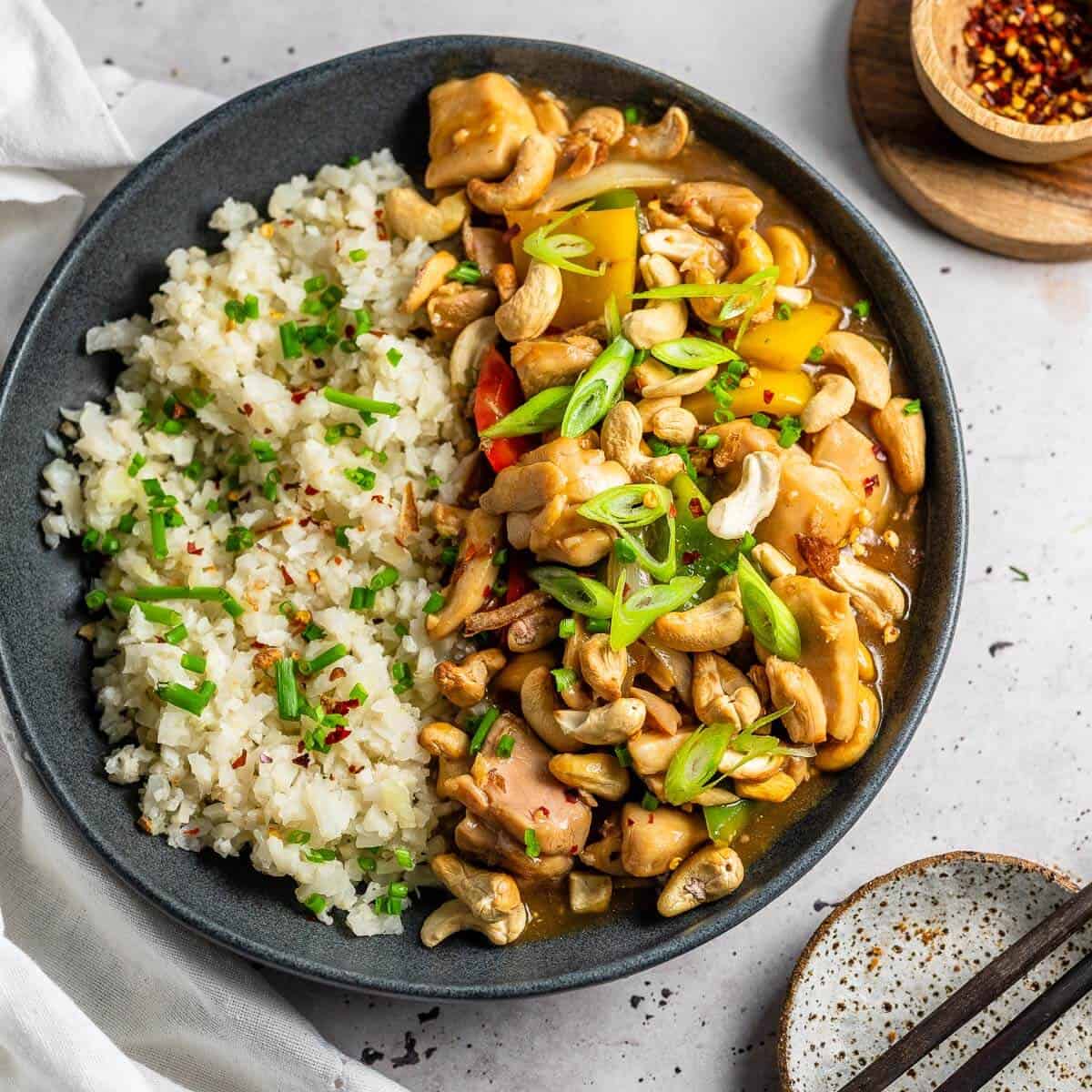 cashew nut chicken in a grey bowl with chopsticks