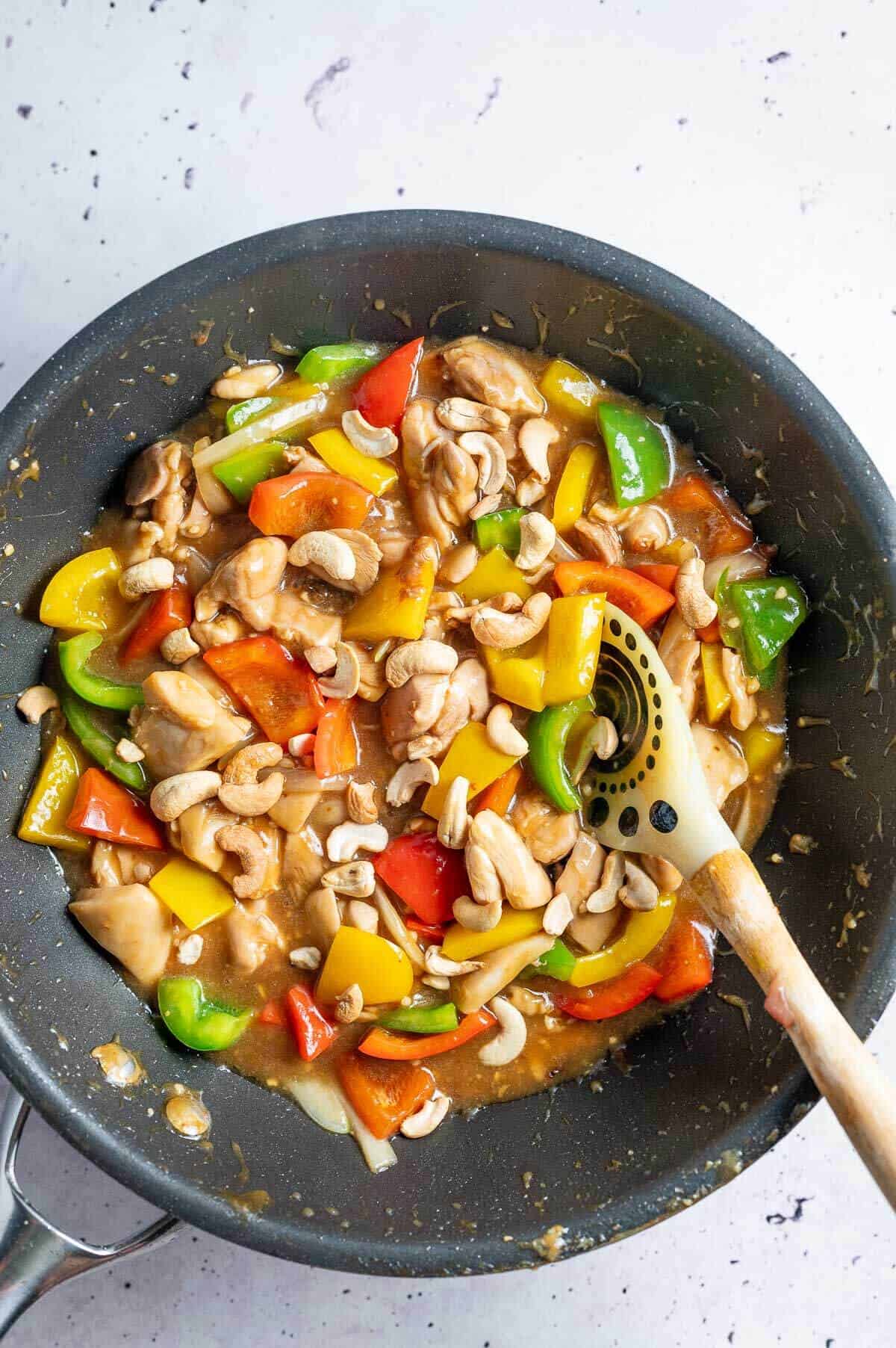 cashew nut chicken in a wok with spoon