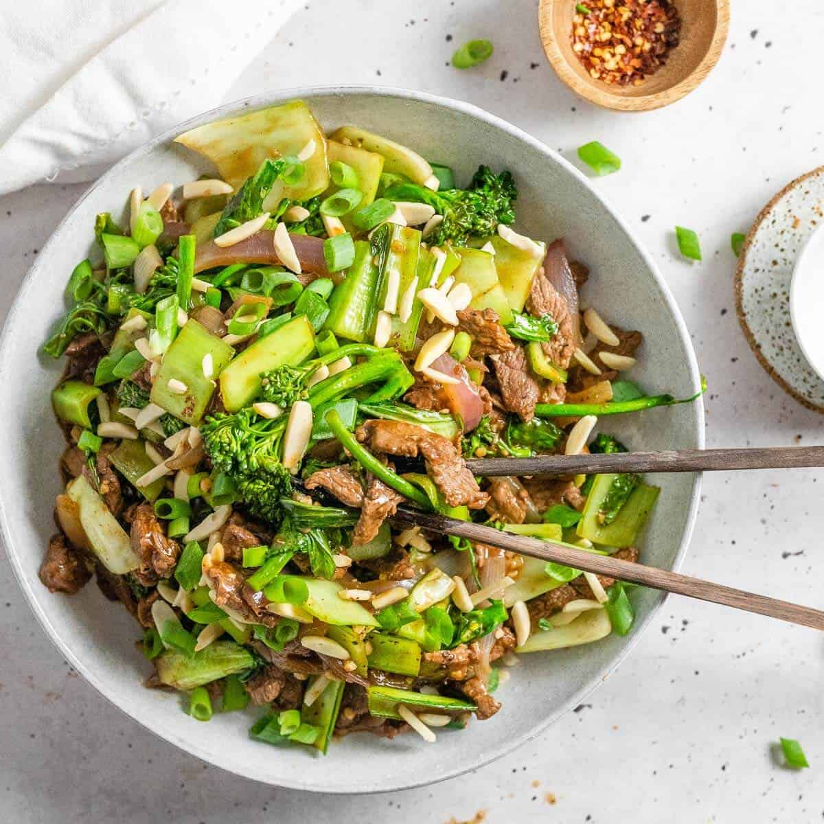 Szechuan Style Beef in a bowl with chopsticks