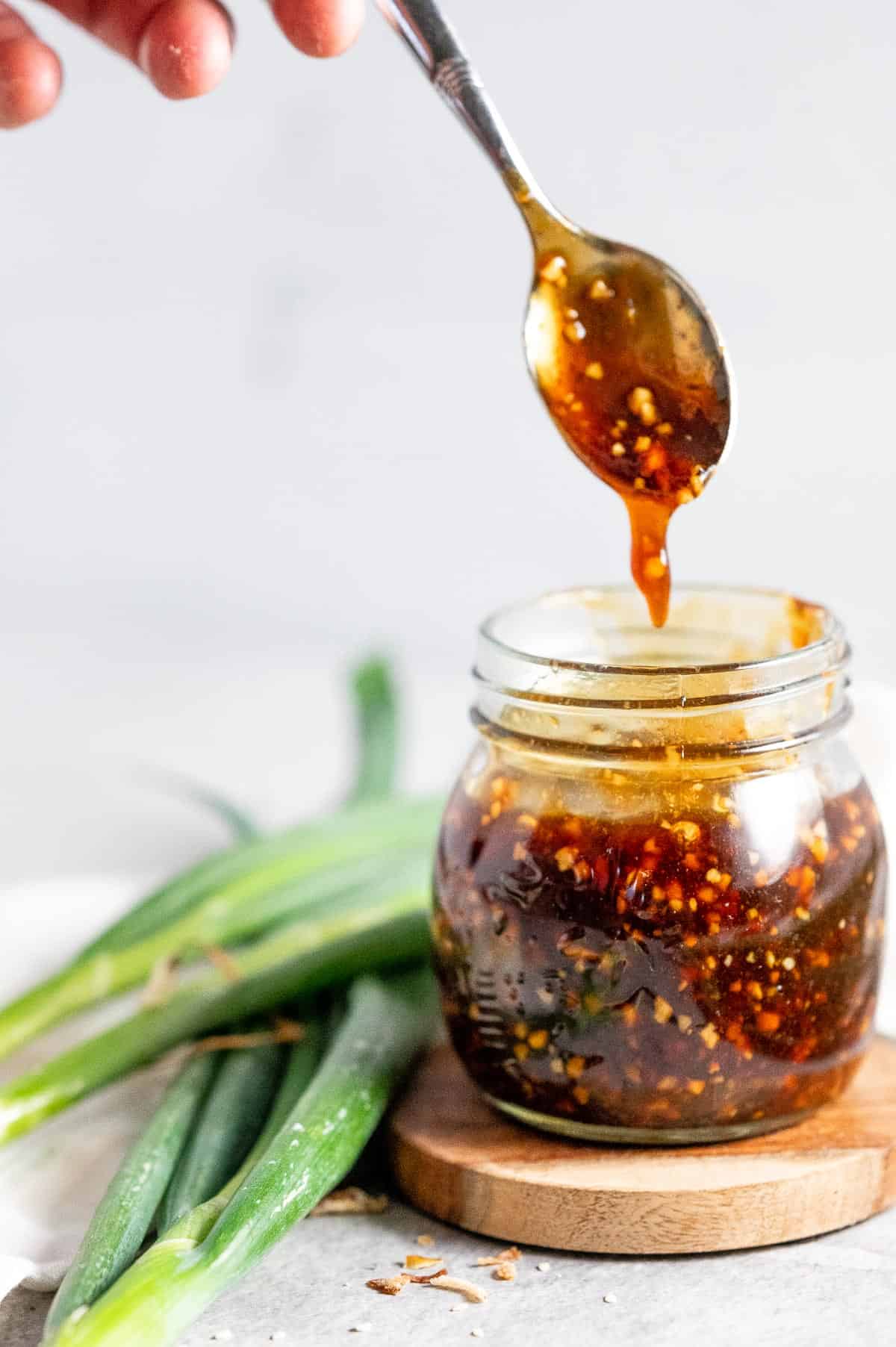 Spoon out teriyaki sauce from a jar