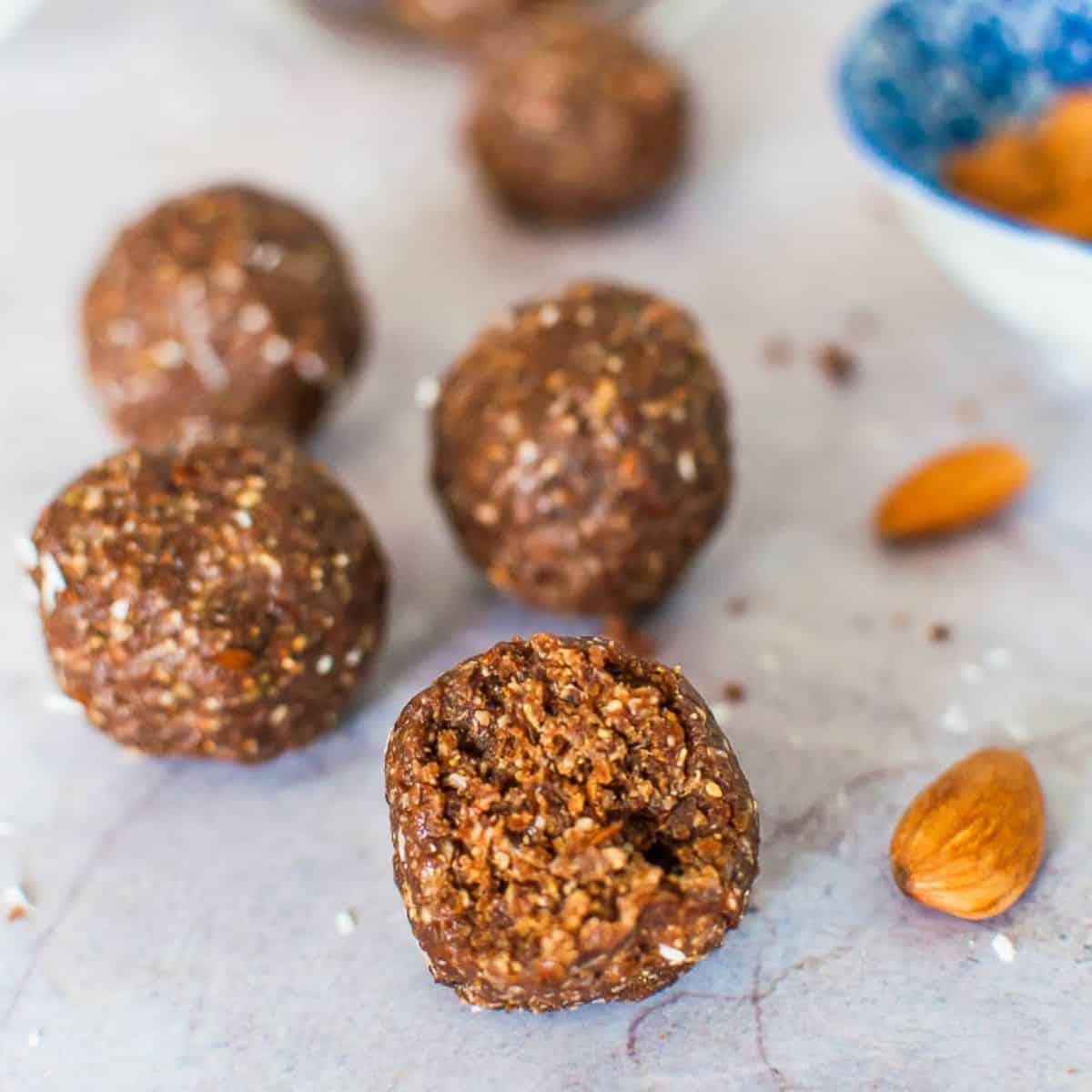 An almond butter bliss ball with a bite out
