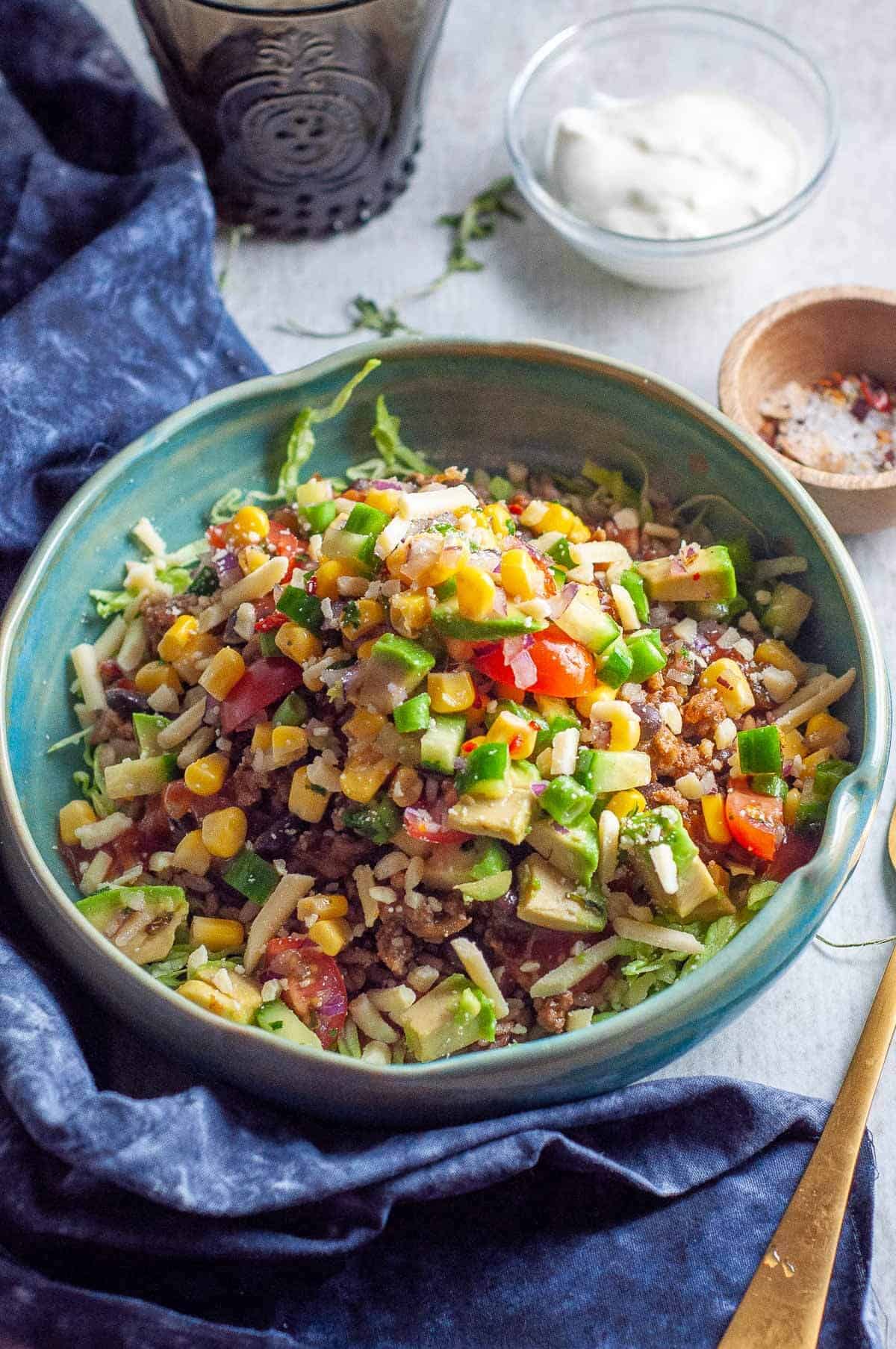 healthy burrito bowl with sour cream and avocado ready to eat