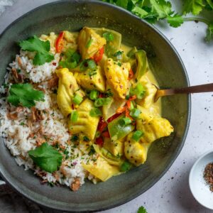 a bowl of kerala fish curry with a fork in