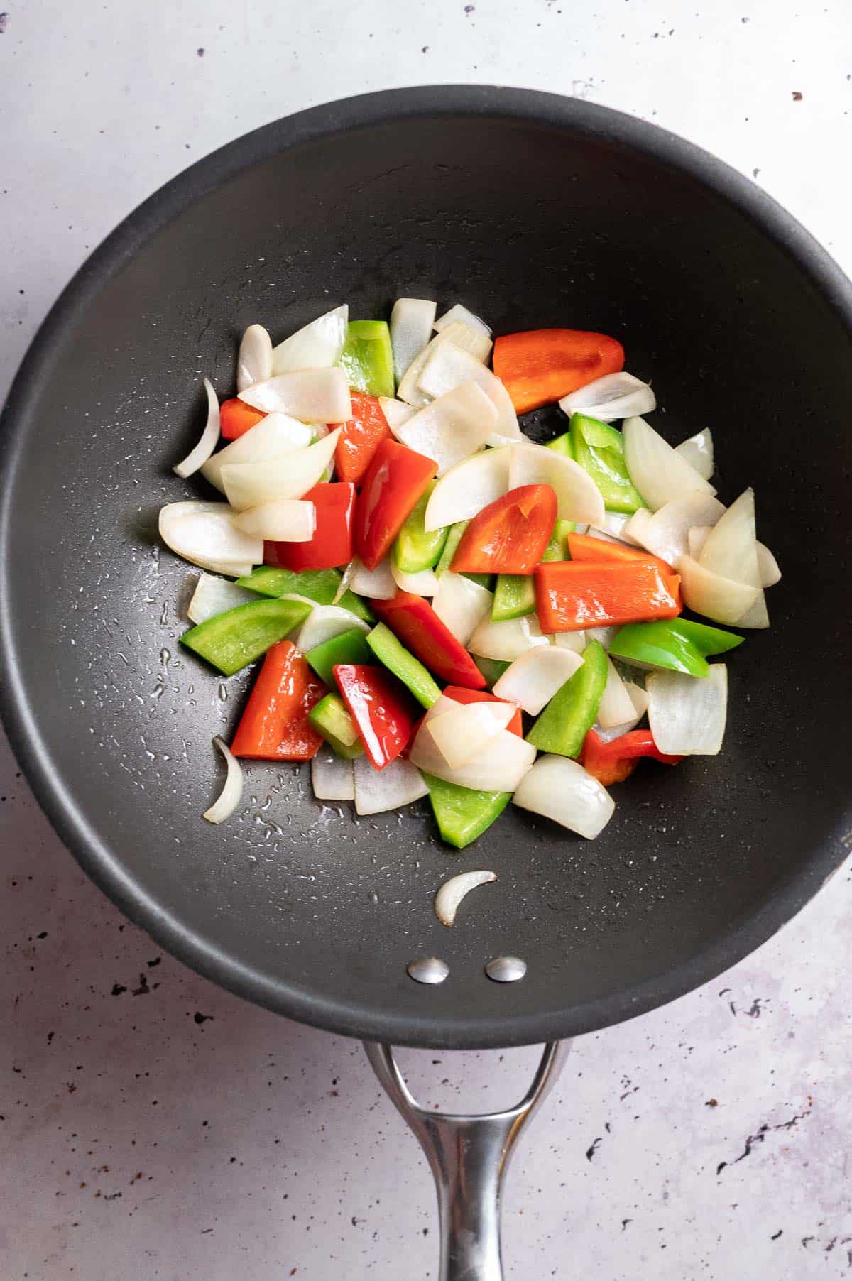 cooking onions and capsicums in a wok