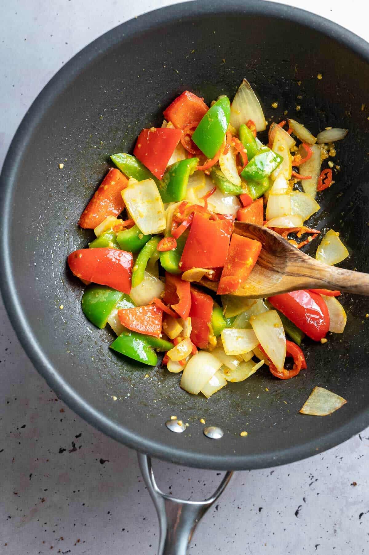 onions, capsicum, garlic and chilli cooking in a wok