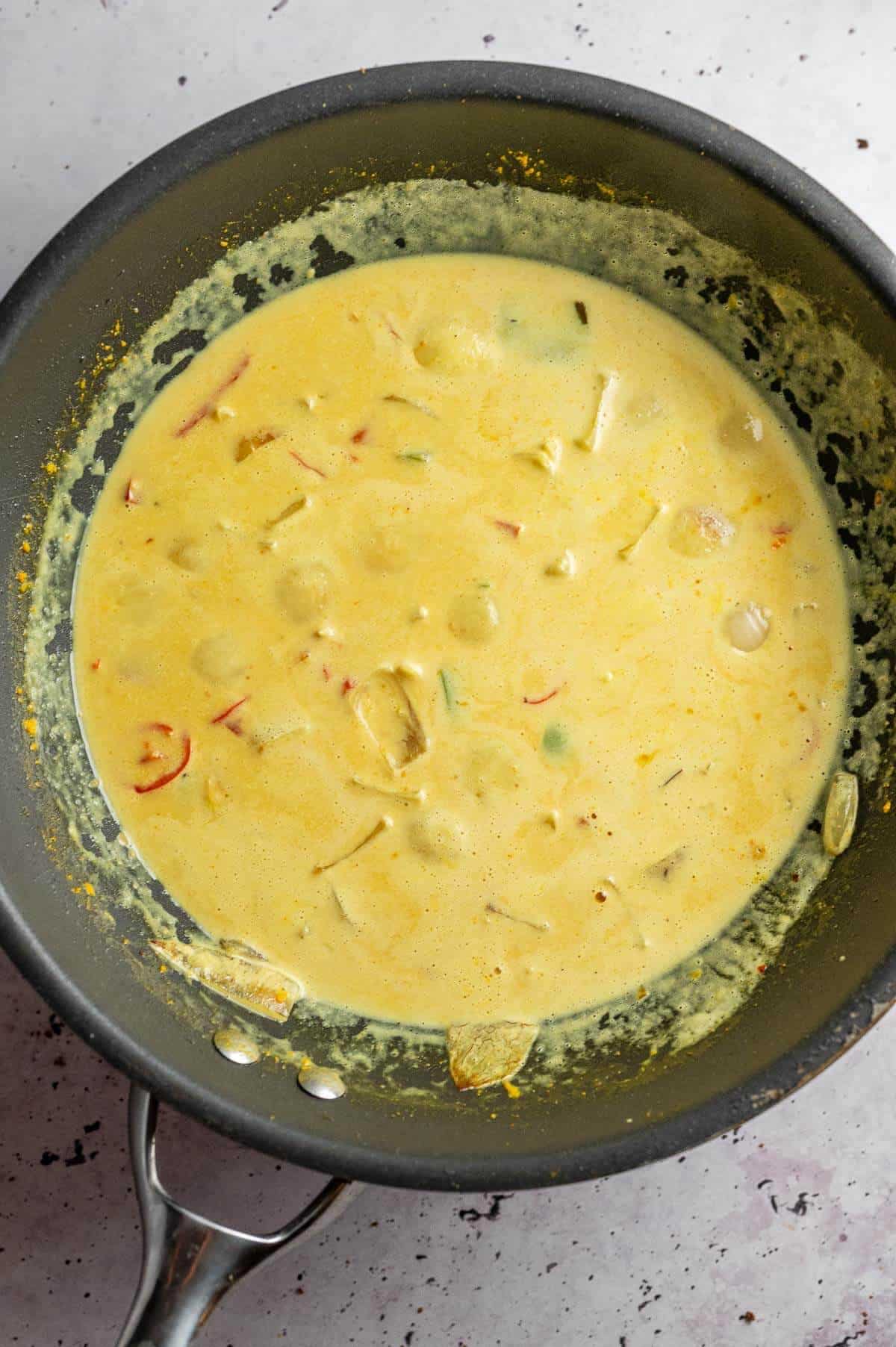 coconut cream curry sauce cooking in a wok