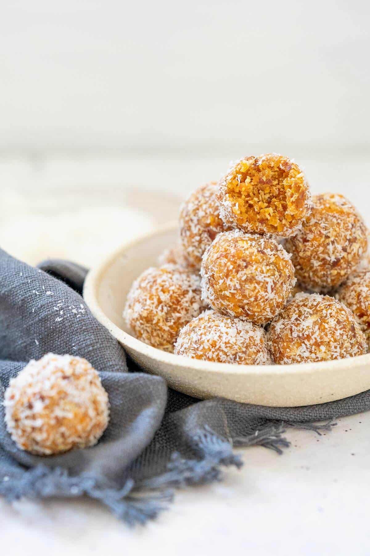 a stack of apricot bliss balls in a white bowl
