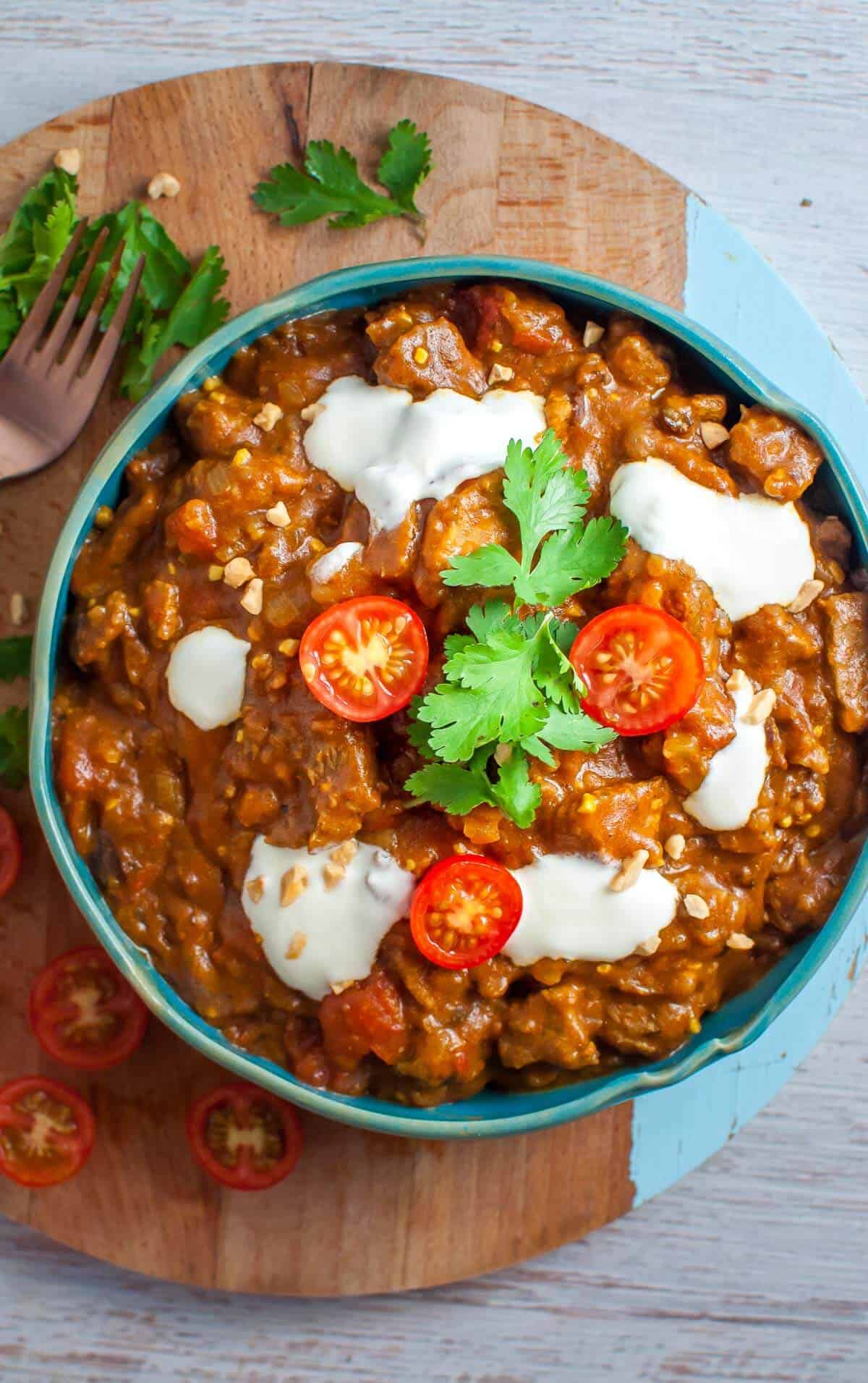 a bowl of beef masala with yoghurt and tomatoes