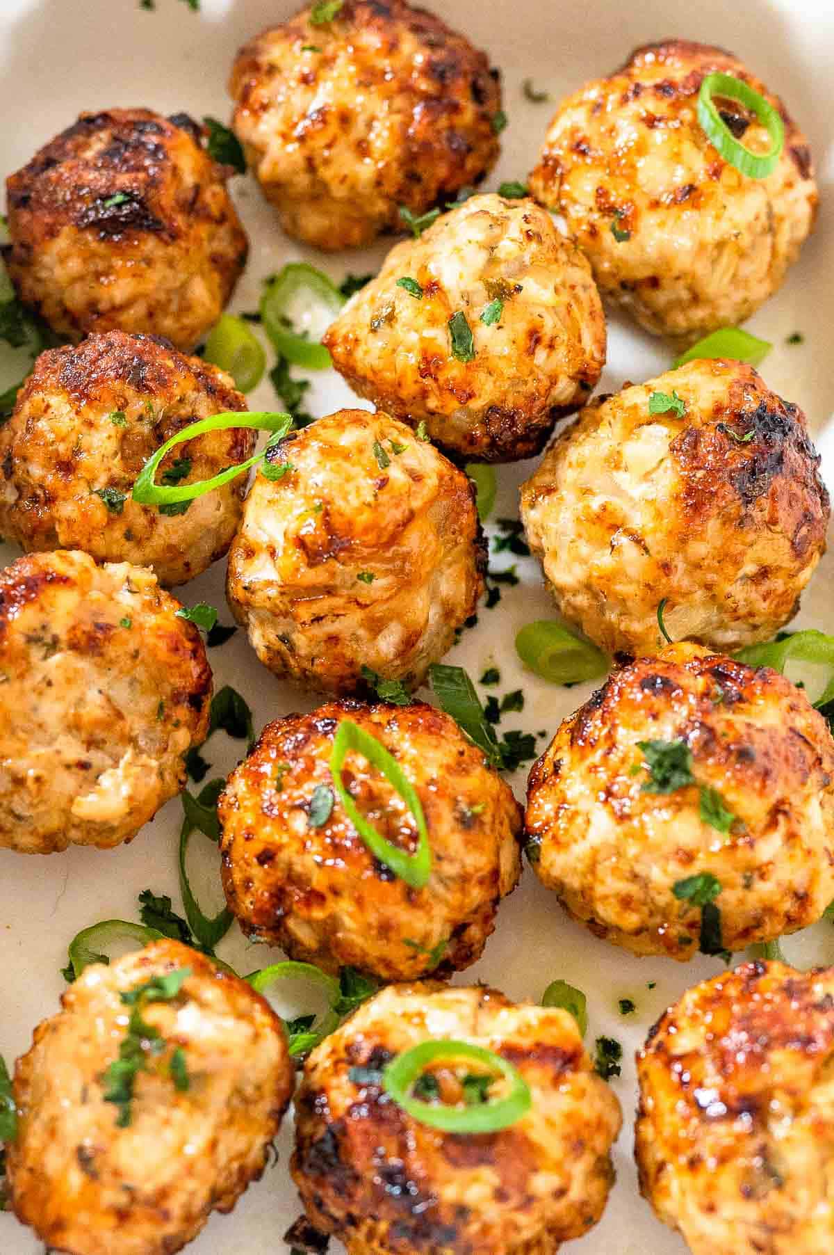 cooked air fryer turkey meatballs garnished with green onions and herbs