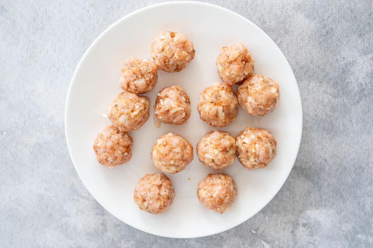 raw air fryer turkey meatballs on a white plate 